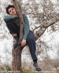 Contact dance workshop participant resting in a tree